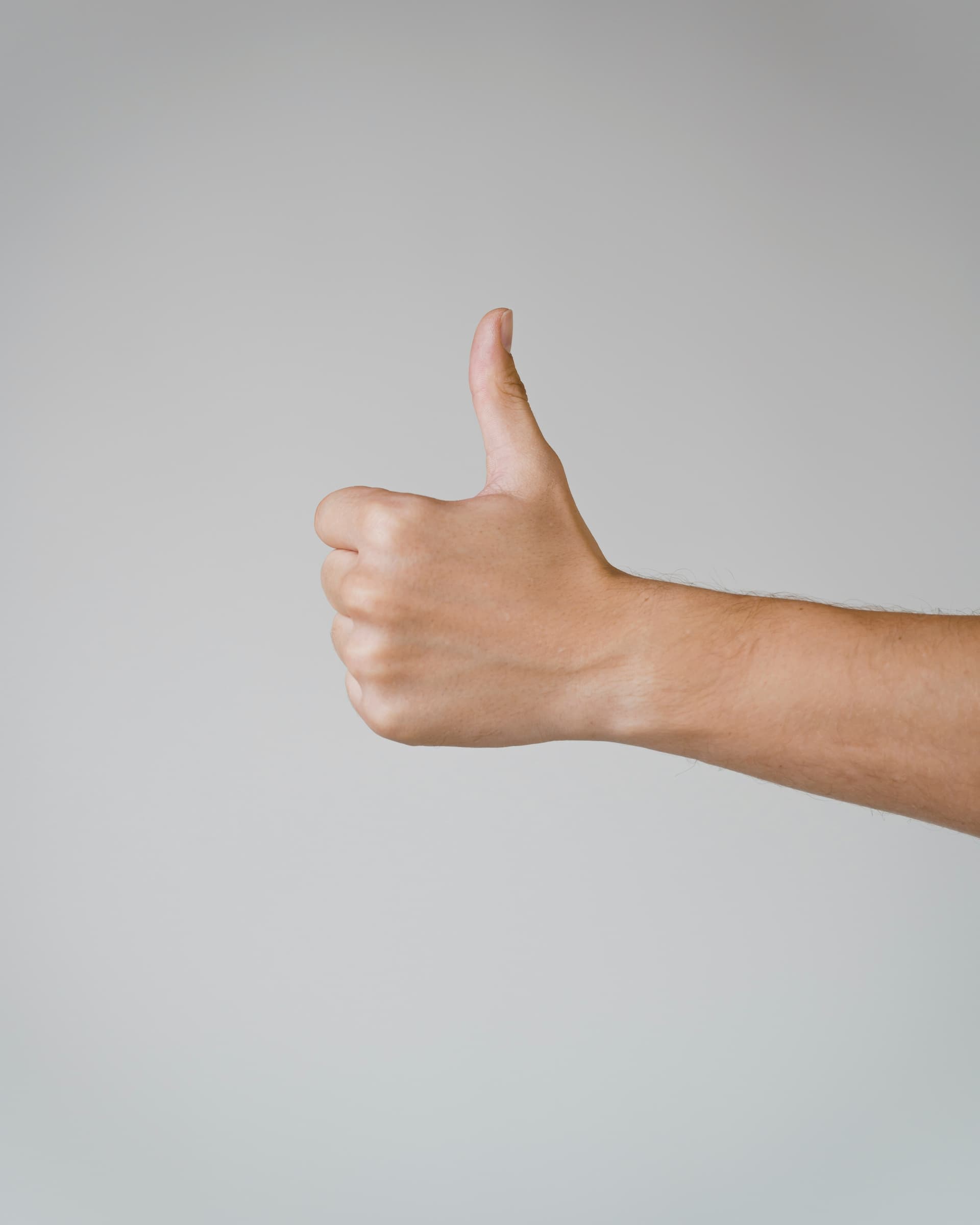 A thumbs-up against a calm gray backdrop, the universal sign of a five-star review.